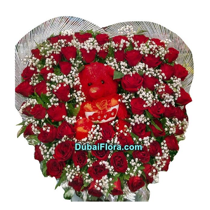 beautifull heart shape  arrangment flowers with a toy 